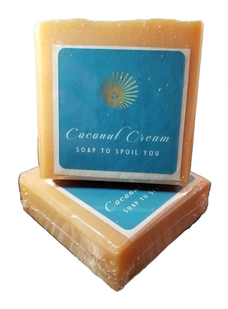 Two Bold Citrus Soap Bars sit against a bright white background. They are a creamy orange color and sport a turquois blue label with Coconut Cream Soap's logo of a smiling yellow sun and the words Coconut Cream Soap to Spoil You